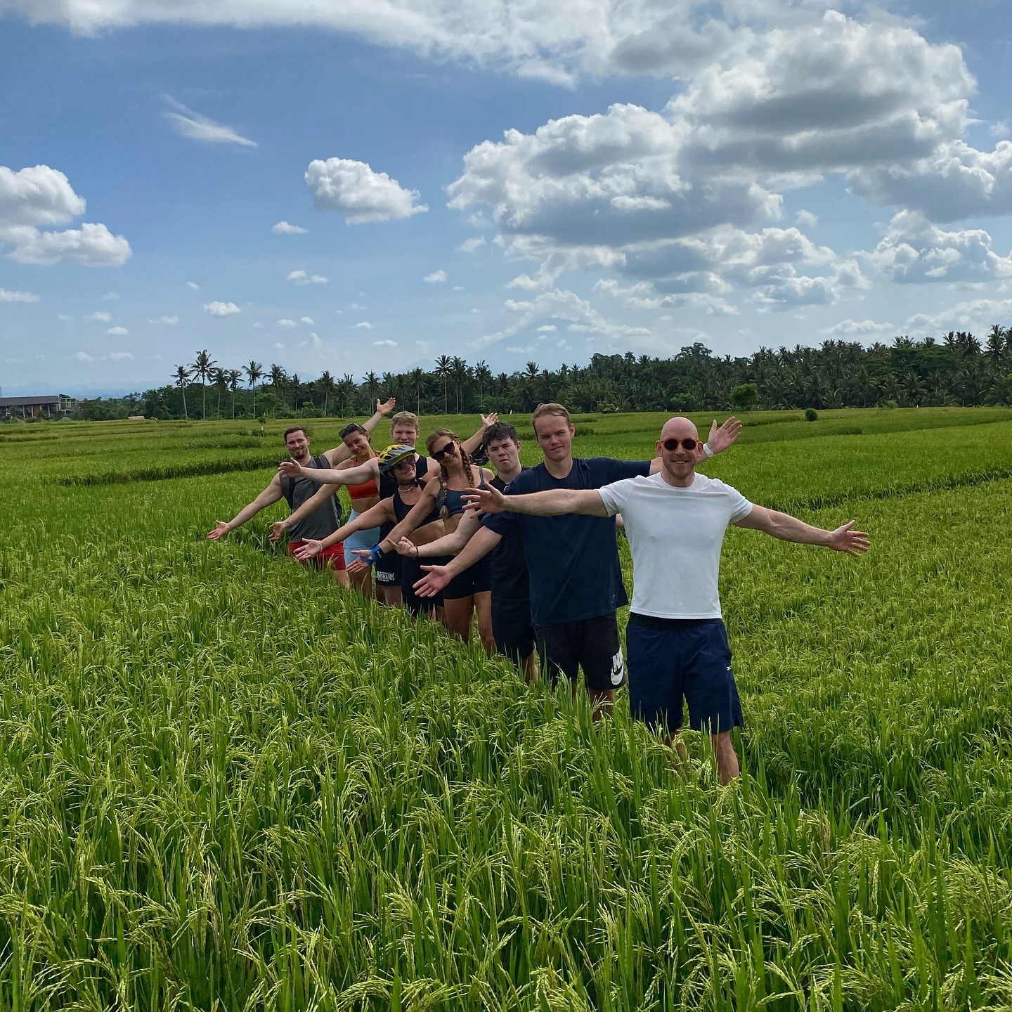 Cycling guests posing among lush Ubud rice fields